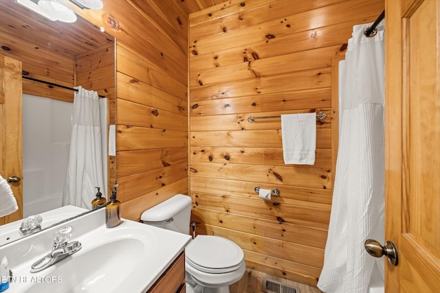 bathroom with toilet, wooden walls, vanity, visible vents, and a shower with curtain