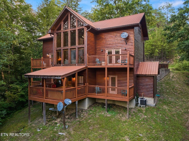 back of house featuring log veneer siding, metal roof, central AC, and a wooden deck