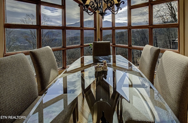 dining room featuring a healthy amount of sunlight, floor to ceiling windows, and a notable chandelier