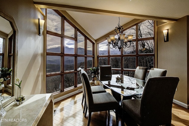 sunroom / solarium with vaulted ceiling with beams and an inviting chandelier