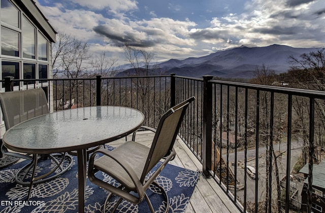 balcony featuring a mountain view and outdoor dining space