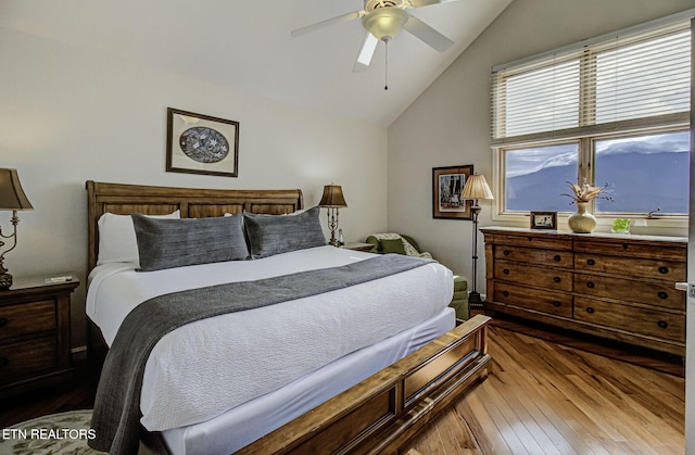 bedroom featuring hardwood / wood-style flooring, vaulted ceiling, and a ceiling fan