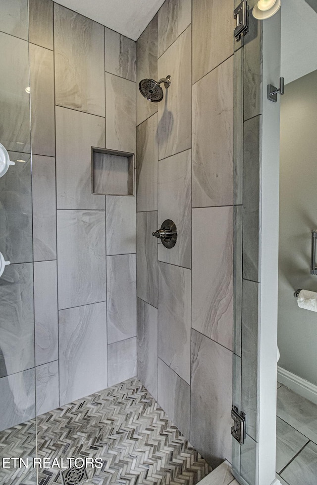 bathroom featuring a stall shower and baseboards