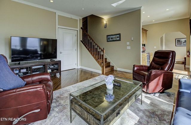 living room featuring arched walkways, ornamental molding, stairway, and wood finished floors