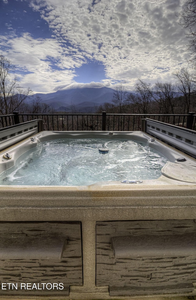 view of swimming pool with a hot tub and a mountain view