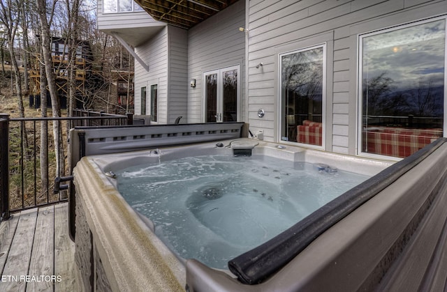 wooden deck featuring a hot tub