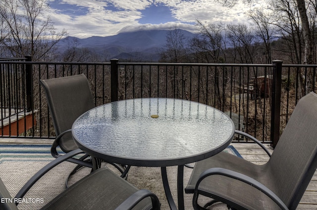 balcony with outdoor dining area and a mountain view