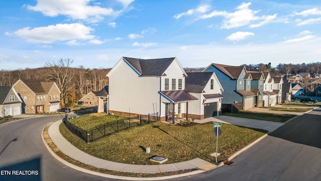 view of front of property featuring a garage, a residential view, driveway, and fence