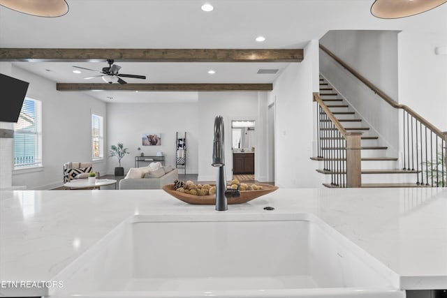 kitchen with visible vents, beam ceiling, a sink, open floor plan, and recessed lighting