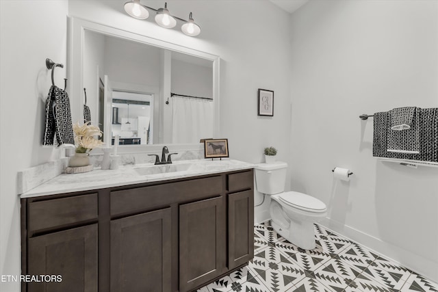 bathroom with tile patterned floors, baseboards, toilet, and vanity