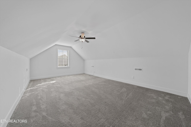 additional living space featuring baseboards, visible vents, carpet floors, lofted ceiling, and ceiling fan