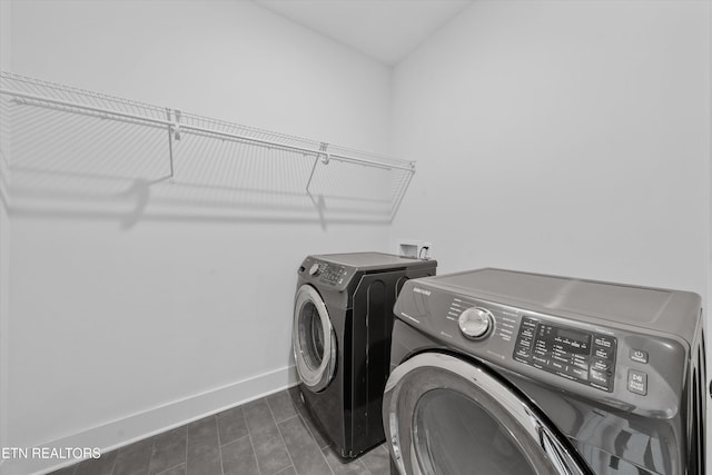 clothes washing area with washer and dryer, laundry area, and baseboards