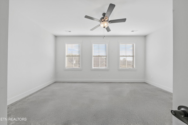 unfurnished room with a wealth of natural light, visible vents, and baseboards