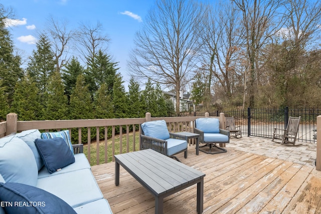 wooden terrace with fence and an outdoor hangout area