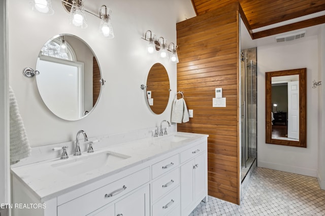 bathroom featuring double vanity, a shower stall, visible vents, and a sink