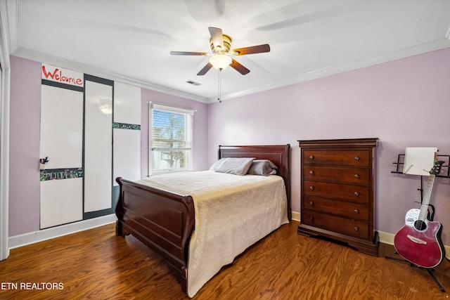 bedroom featuring ornamental molding, wood finished floors, visible vents, and baseboards