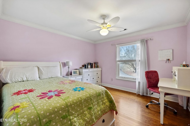 bedroom with a ceiling fan, baseboards, crown molding, and wood finished floors