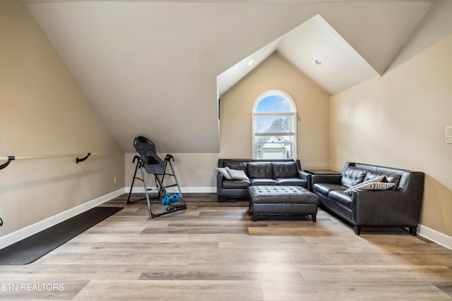 interior space with lofted ceiling, baseboards, and wood finished floors