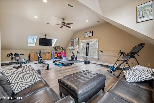 workout room with lofted ceiling with skylight, wood finished floors, visible vents, and baseboards