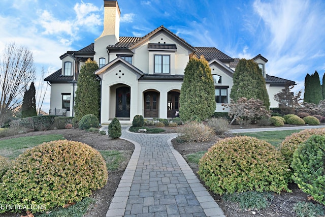 view of front of property with stucco siding and a chimney