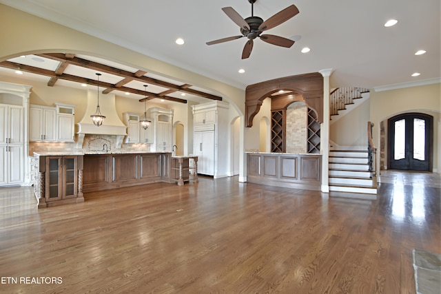 unfurnished living room featuring stairway, wood finished floors, coffered ceiling, recessed lighting, and arched walkways