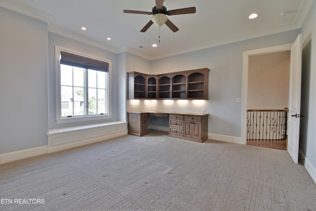 unfurnished office with baseboards, built in desk, and ornamental molding