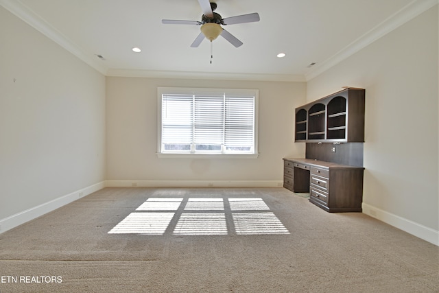 unfurnished office featuring crown molding, light colored carpet, baseboards, and visible vents