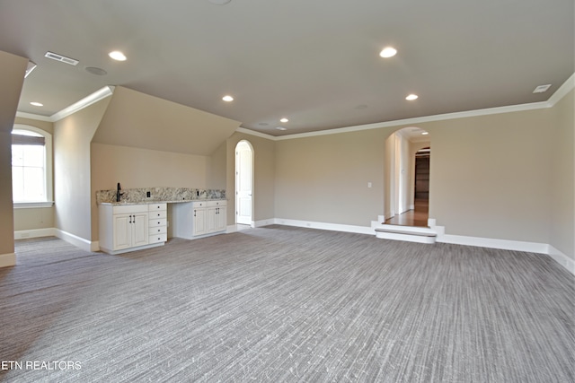 unfurnished living room with baseboards, arched walkways, and visible vents