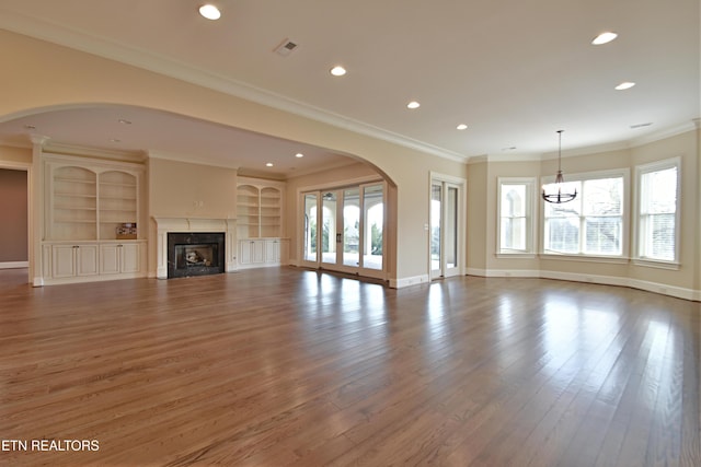 unfurnished living room with visible vents, wood finished floors, recessed lighting, a premium fireplace, and baseboards