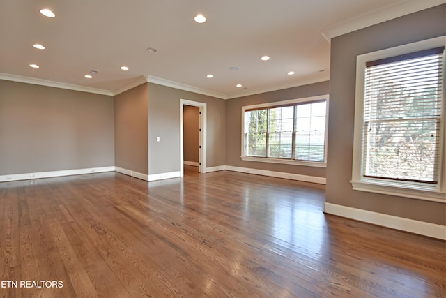 empty room with recessed lighting, ornamental molding, baseboards, and wood finished floors