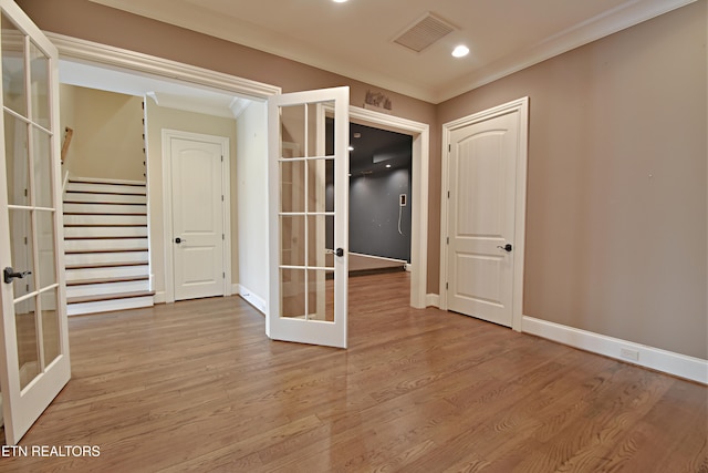 unfurnished room featuring wood finished floors, crown molding, french doors, and visible vents