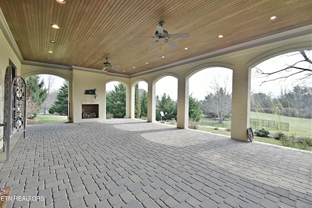 view of patio / terrace with a large fireplace and a ceiling fan