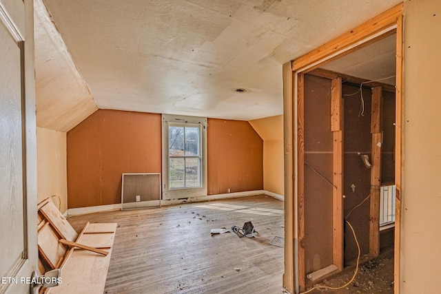 bonus room with vaulted ceiling and wood finished floors