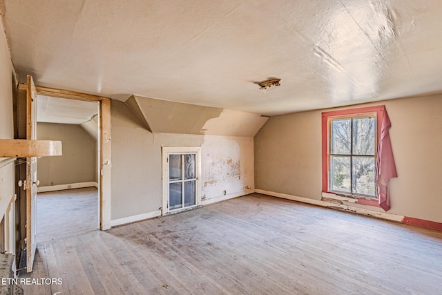 bonus room featuring lofted ceiling, wood-type flooring, and baseboards