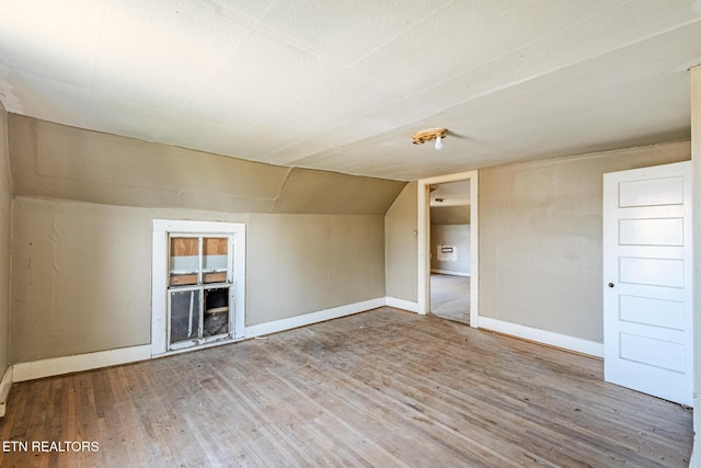 bonus room with lofted ceiling, baseboards, and wood finished floors