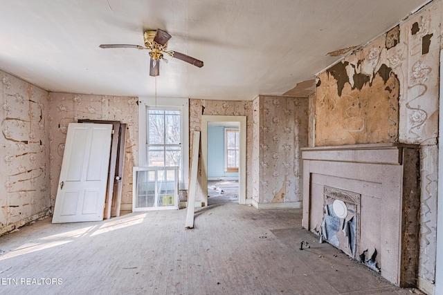 unfurnished living room featuring a ceiling fan