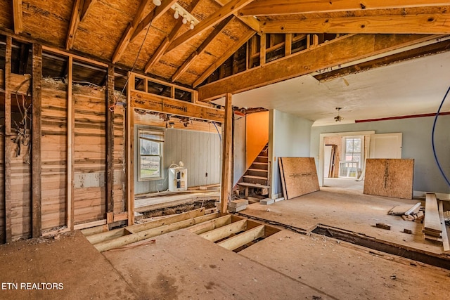 miscellaneous room with lofted ceiling and stairway