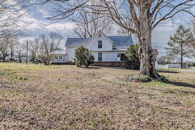 view of side of home featuring metal roof and brick siding