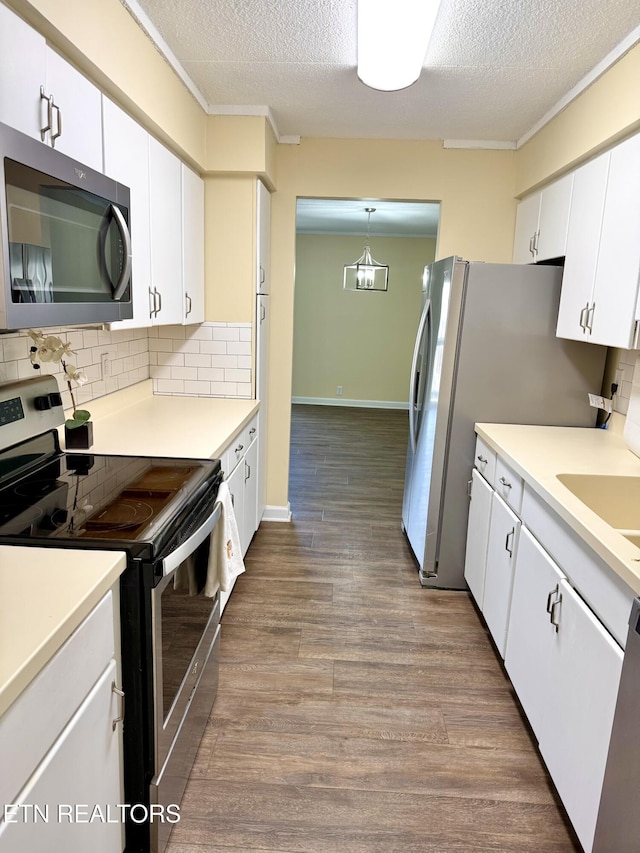 kitchen featuring appliances with stainless steel finishes, dark wood-style flooring, white cabinetry, and decorative backsplash