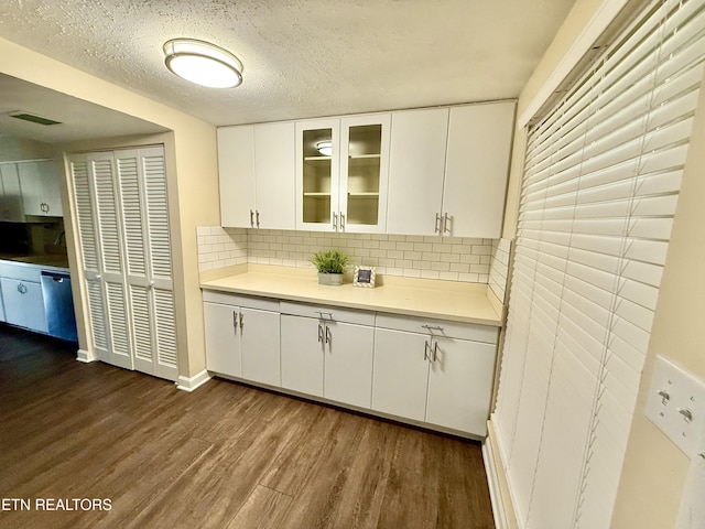 kitchen with dark wood finished floors, light countertops, glass insert cabinets, white cabinetry, and a textured ceiling