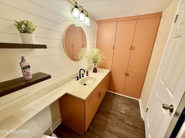 bathroom with a textured ceiling, wood finished floors, and vanity