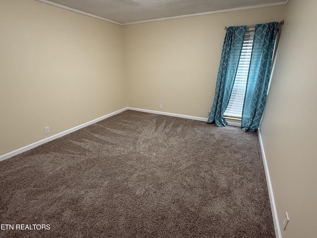 empty room featuring ornamental molding, dark colored carpet, a textured ceiling, and baseboards