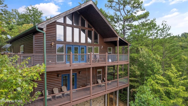 back of property featuring faux log siding and a wooden deck