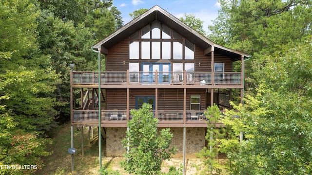 back of house with faux log siding and a wooden deck