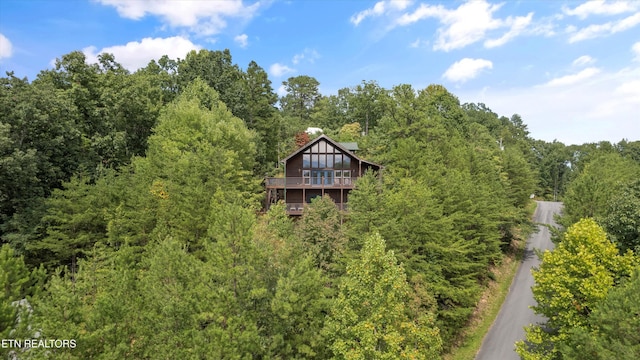 exterior space featuring a chimney, a wooden deck, and a wooded view