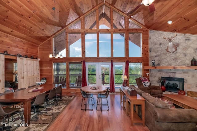 living room featuring wood ceiling, wooden walls, a fireplace, and wood finished floors