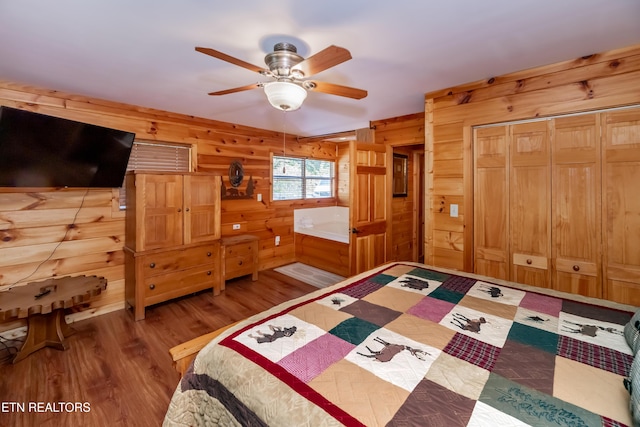 unfurnished bedroom with wood walls and wood finished floors
