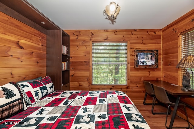 unfurnished bedroom with wooden walls and wood finished floors
