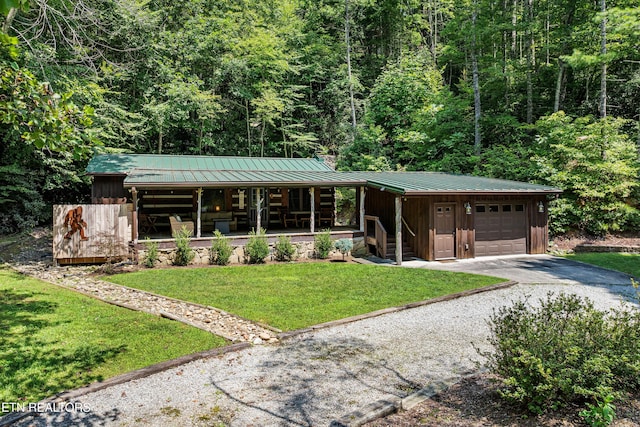 view of front of house featuring covered porch, an attached garage, board and batten siding, a standing seam roof, and driveway