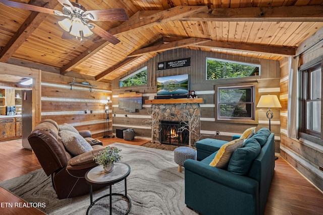 living room with lofted ceiling with beams, hardwood / wood-style floors, a fireplace, and wooden ceiling